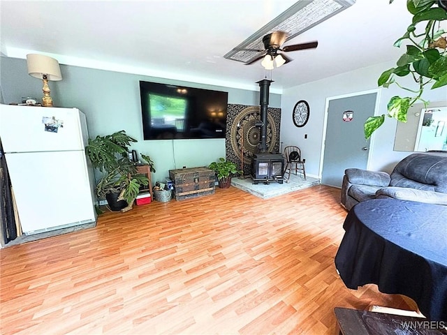 6817 Revere Dr, Evans, NY 14047 - living room featuring a wood stove, light wood-type flooring, and a ceiling fan