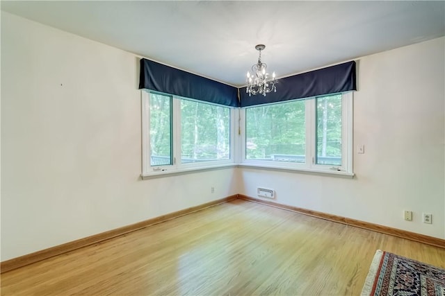 120 Scotch Ln, Irondequoit, NY 14617 - unfurnished room with a chandelier, wood finished floors, and baseboards