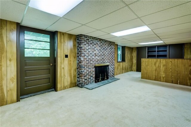 120 Scotch Ln, Irondequoit, NY 14617 - below grade area featuring carpet floors, a paneled ceiling, a fireplace, and wooden walls