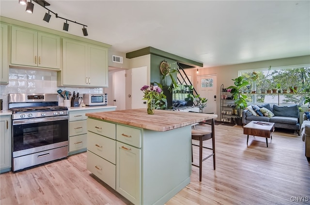 435 Elm St, Ithaca City, NY 14850 - kitchen with gas range, butcher block counters, tasteful backsplash, a kitchen bar, and rail lighting