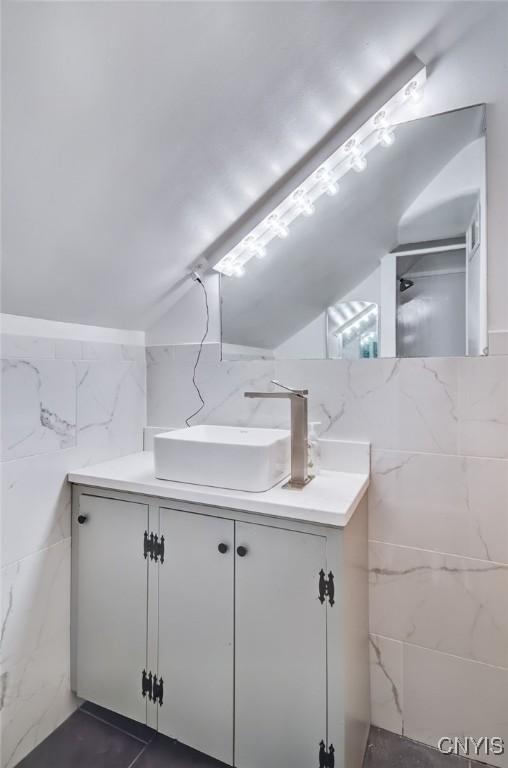 435 Elm St, Ithaca City, NY 14850 - full bathroom featuring tile walls, vanity, a shower, and lofted ceiling