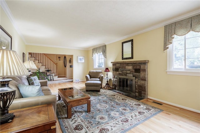 654 Lake Shore Blvd, Irondequoit, NY 14617 - living room featuring stairs, wood finished floors, crown molding, a stone fireplace, and baseboards