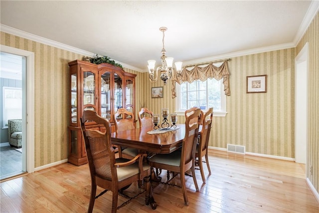 654 Lake Shore Blvd, Irondequoit, NY 14617 - dining space featuring a chandelier, light wood-style flooring, wallpapered walls, ornamental molding, and baseboards