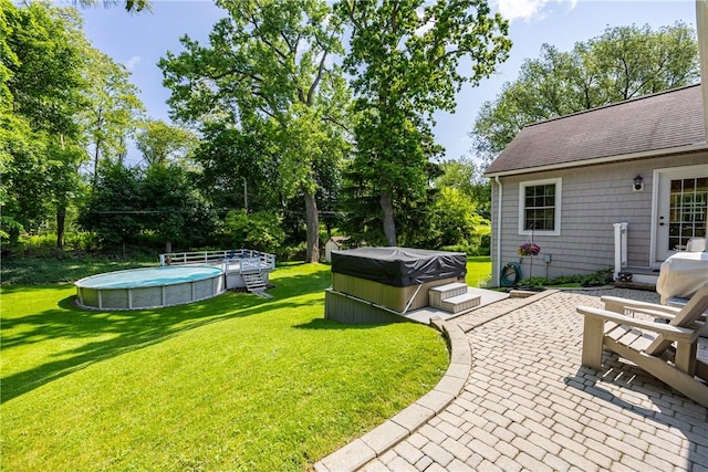 654 Lake Shore Blvd, Irondequoit, NY 14617 - view of green lawn with a hot tub, an outdoor pool, a patio, and view of wooded area
