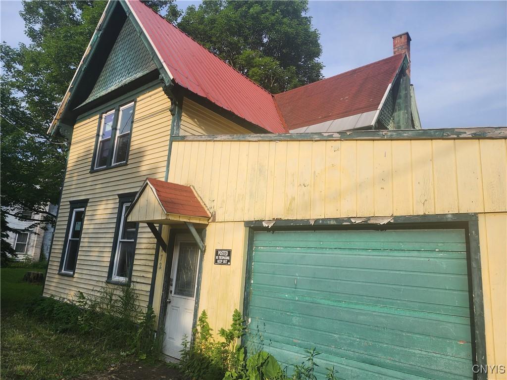 472 Main St, Russia, NY 13324 - view of front facade with a garage and a chimney