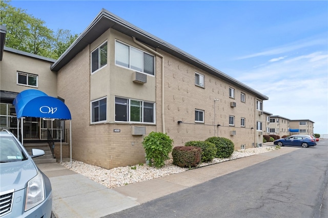 406 Westage At The Hbr, Irondequoit, NY 14617 - view of home's exterior with brick siding and a wall mounted air conditioner