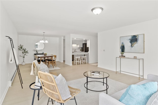 406 Westage At The Hbr, Irondequoit, NY 14617 - living room featuring a baseboard heating unit, a chandelier, light wood finished floors, and baseboards