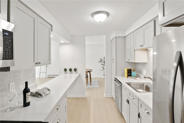 406 Westage At The Hbr, Irondequoit, NY 14617 - kitchen featuring appliances with stainless steel finishes, a sink, light countertops, backsplash, and baseboards