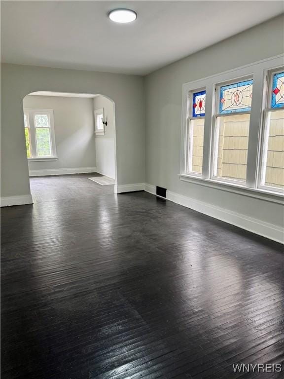 711 W Ave, Buffalo, NY 14213 - spare room featuring arched walkways, dark wood-style floors, and baseboards