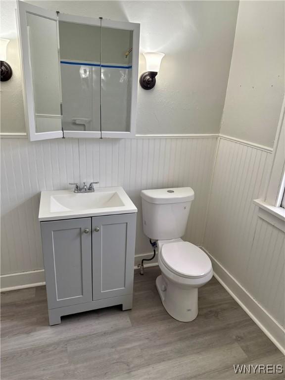 711 W Ave, Buffalo, NY 14213 - bathroom featuring a wainscoted wall, vanity, toilet, and wood finished floors