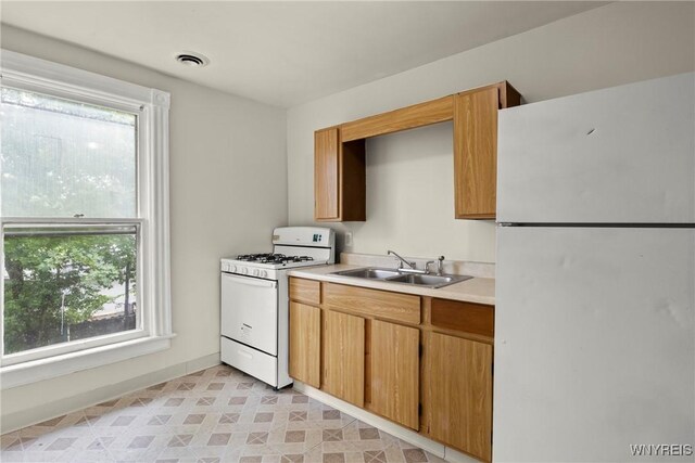 89 Pine St, Lockport-City, NY 14094 - kitchen featuring white appliances, plenty of natural light, light countertops, and a sink