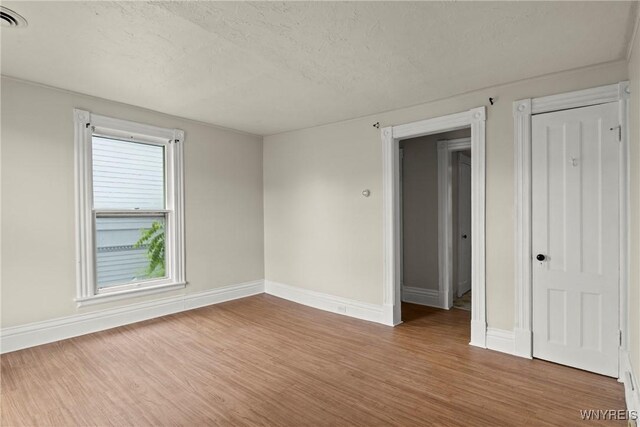 89 Pine St, Lockport-City, NY 14094 - spare room with wood finished floors, baseboards, and a textured ceiling