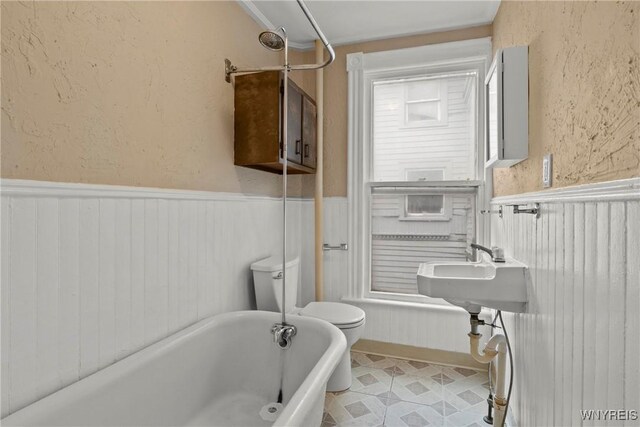 89 Pine St, Lockport-City, NY 14094 - bathroom with a tub to relax in, a wainscoted wall, and toilet