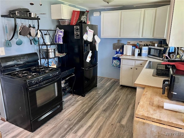 7400 Saint Joseph Rd, Niagara, NY 14304 - kitchen featuring black appliances, light countertops, wood finished floors, and white cabinets