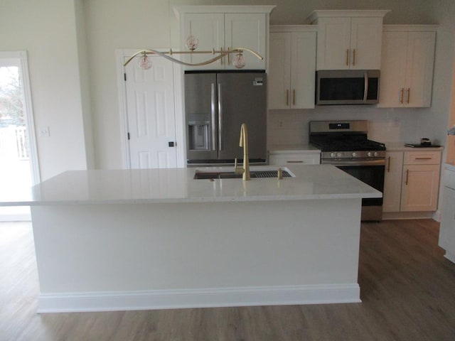 6 Royal Ct, Horseheads, NY 14845 - kitchen featuring stainless steel appliances, wood finished floors, a center island with sink, tasteful backsplash, and white cabinets