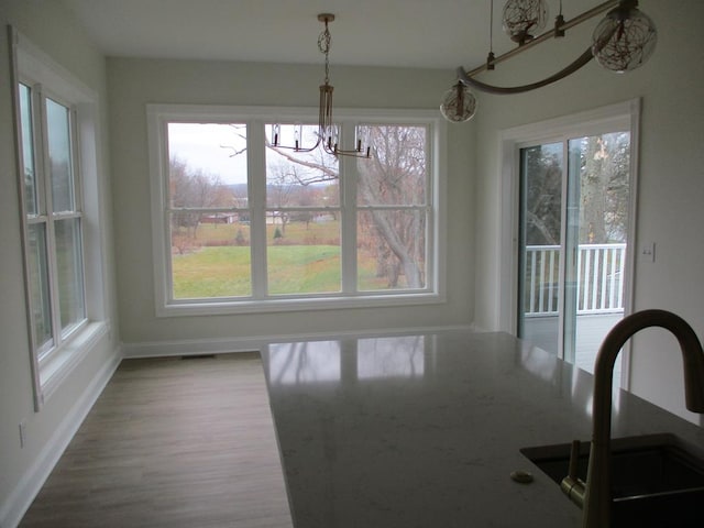 6 Royal Ct, Horseheads, NY 14845 - unfurnished dining area featuring a sink, a chandelier, baseboards, and wood finished floors