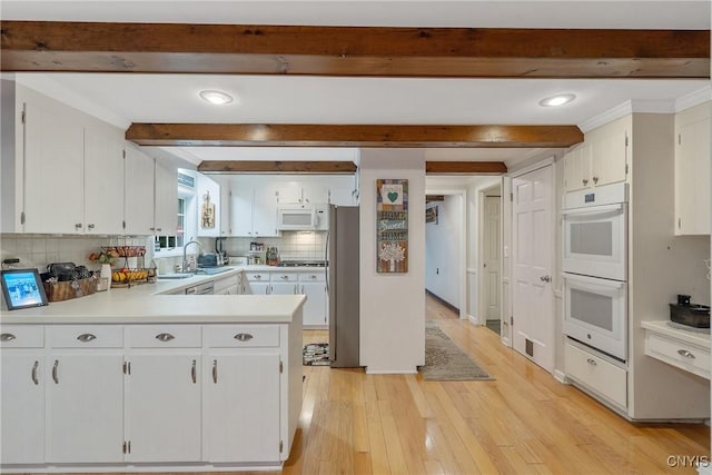 223 Windcrest Dr, Camillus, NY 13031 - kitchen with white appliances, beamed ceiling, a peninsula, light wood-style floors, and tasteful backsplash