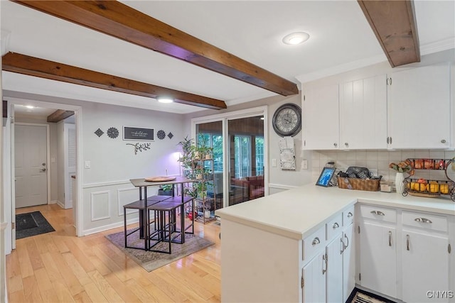223 Windcrest Dr, Camillus, NY 13031 - kitchen featuring light countertops, a peninsula, white cabinetry, beam ceiling, and decorative backsplash