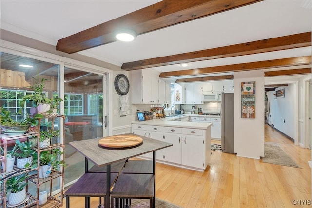 223 Windcrest Dr, Camillus, NY 13031 - kitchen with white microwave, freestanding refrigerator, healthy amount of natural light, beamed ceiling, and white cabinetry