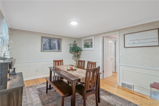 223 Windcrest Dr, Camillus, NY 13031 - dining space featuring wallpapered walls, a decorative wall, wood finished floors, and wainscoting