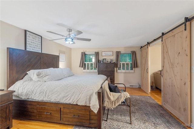 223 Windcrest Dr, Camillus, NY 13031 - bedroom featuring a barn door, light wood-style floors, and ceiling fan