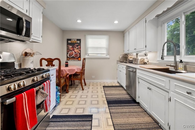 123 Hillcrest Rd, Onondaga, NY 13219 - kitchen with stainless steel appliances, a sink, healthy amount of natural light, white cabinets, and recessed lighting