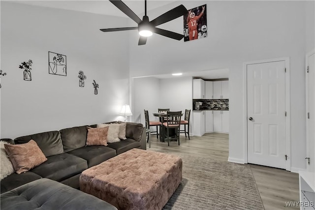 4613 Chestnut Ridge Rd Unit F, Amherst, NY 14228 - living area featuring a high ceiling, a ceiling fan, light wood-type flooring, and baseboards