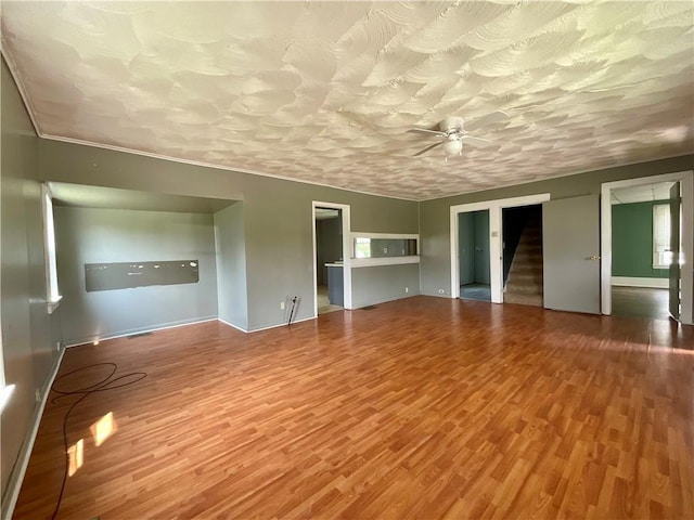 201 S Main St, Wayland, NY 14572 - unfurnished living room featuring a ceiling fan, wood finished floors, stairs, and baseboards