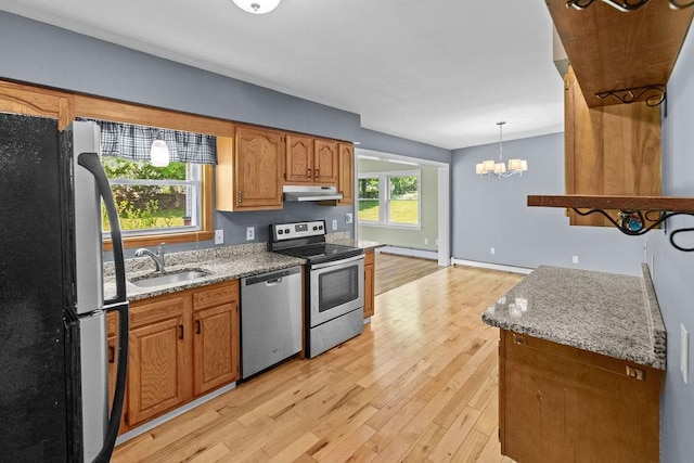 26 Prospect St, Delhi, NY 13753 - kitchen with stainless steel appliances, under cabinet range hood, a sink, a baseboard radiator, and a chandelier