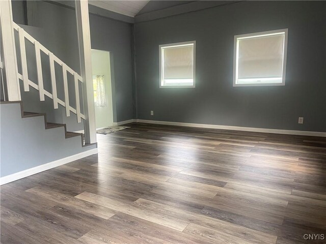 8807 N Main St, Le Ray, NY 13637 - empty room with vaulted ceiling, stairway, dark wood-type flooring, and baseboards