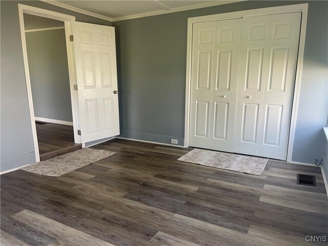 8807 N Main St, Le Ray, NY 13637 - unfurnished bedroom featuring a closet, ornamental molding, dark wood-style floors, and baseboards