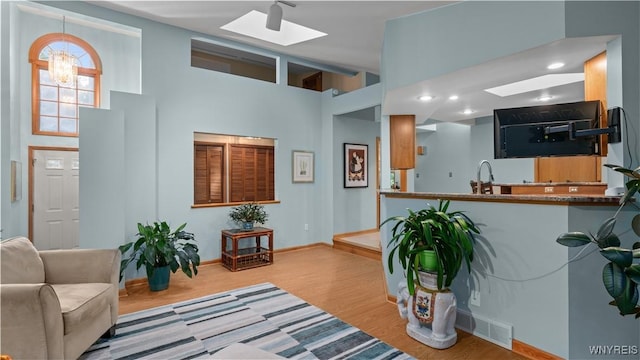 43 Larned Ln, Orchard Park, NY 14127 - living room featuring a skylight, wood finished floors, and a high ceiling