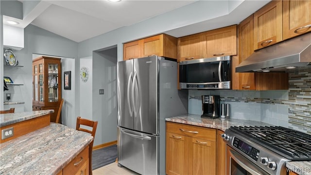 43 Larned Ln, Orchard Park, NY 14127 - kitchen with appliances with stainless steel finishes, under cabinet range hood, tasteful backsplash, light stone countertops, and brown cabinets