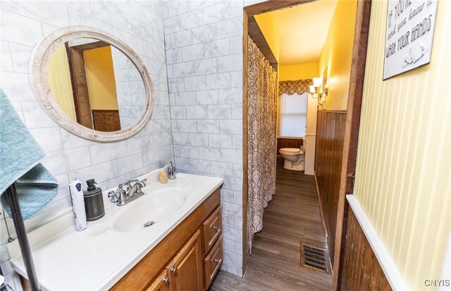 7750 State Route 812, New Bremen, NY 13367 - bathroom featuring tile walls, vanity, wood finished floors, and toilet
