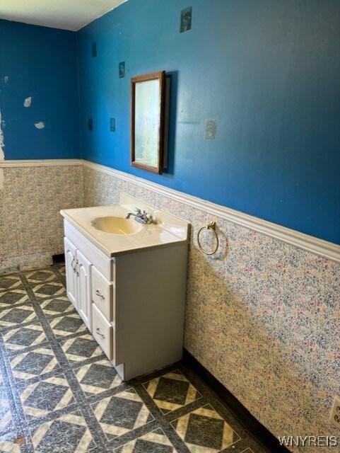 7491 S Grove Rd, Lyndon, NY 14737 - bathroom featuring a wainscoted wall, vanity, and tile walls