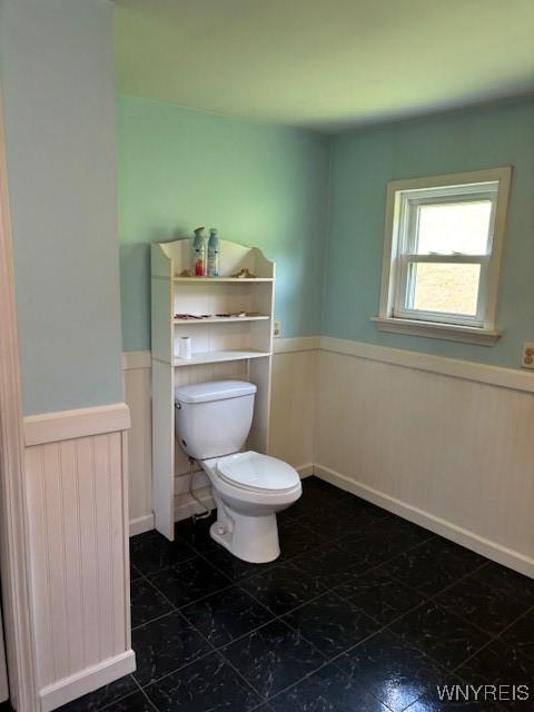 7491 S Grove Rd, Lyndon, NY 14737 - bathroom featuring a wainscoted wall, toilet, and tile patterned flooring