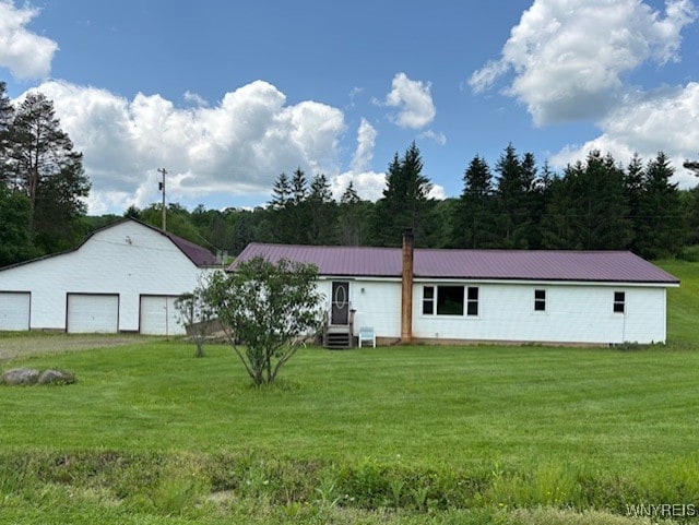 7491 S Grove Rd, Lyndon, NY 14737 - view of front of home featuring a garage, a front lawn, and metal roof