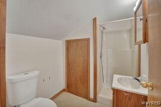 3271 Rte 78, Wethersfield, NY 14024 - bathroom with vanity, toilet, and vaulted ceiling