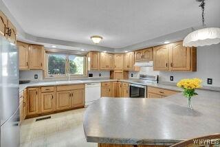 3271 Rte 78, Wethersfield, NY 14024 - kitchen featuring under cabinet range hood, appliances with stainless steel finishes, light countertops, and a peninsula