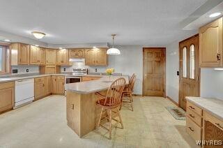 3271 Rte 78, Wethersfield, NY 14024 - kitchen featuring dishwasher, a kitchen breakfast bar, stainless steel range, light countertops, and pendant lighting