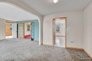 3271 Rte 78, Wethersfield, NY 14024 - unfurnished room with arched walkways, carpet, and baseboards