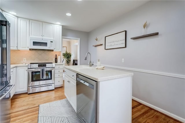99 Hoover Rd, Irondequoit, NY 14617 - kitchen with stainless steel appliances, white cabinets, light countertops, recessed lighting, and decorative backsplash