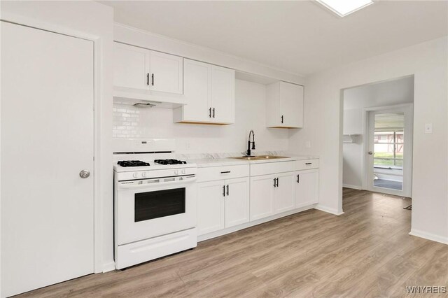 126 Pryor Ave, Tonawanda, NY 14150 - kitchen featuring white range with gas stovetop, under cabinet range hood, light countertops, white cabinetry, and light wood finished floors