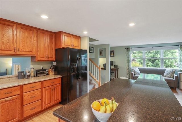 4330 Cinnamon Path, Clay, NY 13090 - kitchen with black fridge, recessed lighting, brown cabinetry, dark stone counters, and open floor plan