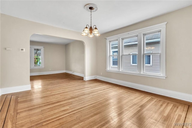 88 Rugby Rd, Buffalo, NY 14216 - spare room with arched walkways, light wood-type flooring, and a chandelier