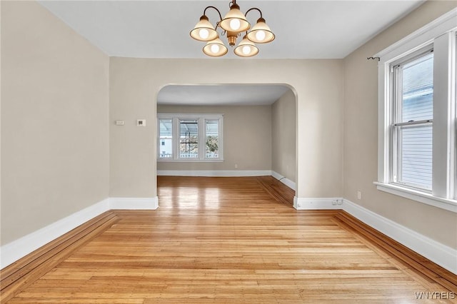 88 Rugby Rd, Buffalo, NY 14216 - spare room with arched walkways, light wood-style floors, and a chandelier