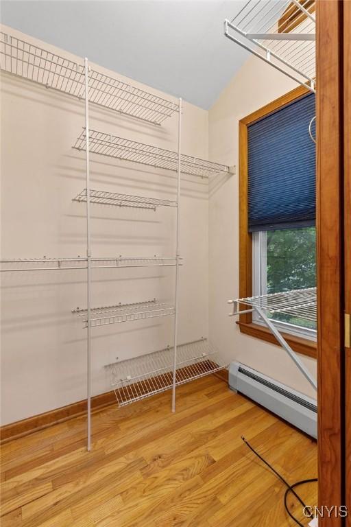 814 Oswego St, Salina, NY 13088 - spacious closet with a baseboard heating unit, light wood-style flooring, and lofted ceiling
