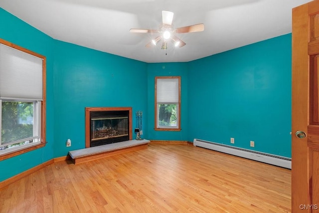 814 Oswego St, Salina, NY 13088 - unfurnished living room featuring baseboard heating, wood finished floors, ceiling fan, and a glass covered fireplace