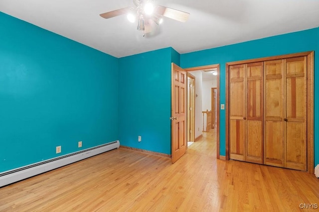 814 Oswego St, Salina, NY 13088 - unfurnished bedroom featuring a baseboard radiator, light wood-style floors, ceiling fan, and a closet