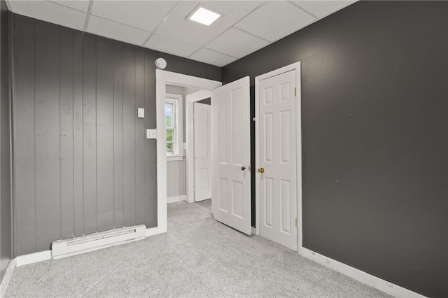328 W Main St, Palmyra, NY 14522 - spare room with a baseboard radiator, carpet flooring, a drop ceiling, and wooden walls